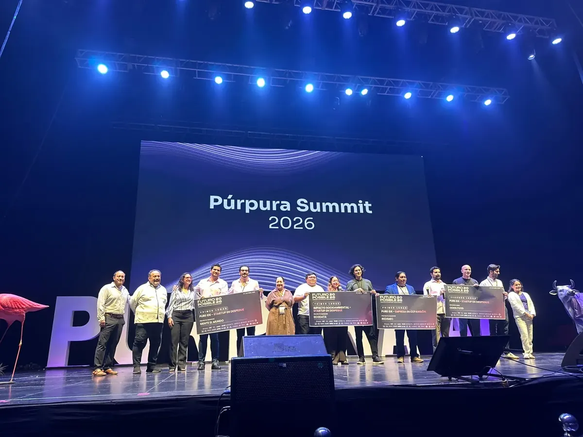 Ganadores de Futuro Posible 2026 en el escenario del Púrpura Summit 2026, con sus cheques de premiación.