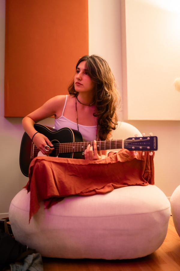 Artista con guitarra durante una sesión del campamento.